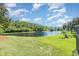 Beautiful backyard view overlooking a pond with a fountain, lush greenery, and blue skies at 3896 Esplanade Ave, Port Orange, FL 32129