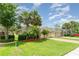 Landscaped front yard showcasing lush green grass and mature trees with a brick driveway at 3896 Esplanade Ave, Port Orange, FL 32129