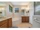 Main bathroom features a soaking tub, double sinks, a window, and ample cabinet storage at 3896 Esplanade Ave, Port Orange, FL 32129