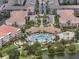Aerial view of the condo community with a resort-style pool and buildings with terra cotta roofs at 4804 Cayview Ave # 20512, Orlando, FL 32819