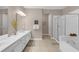 Well-lit bathroom with double sink vanity, soaking tub, and glass shower enclosure at 4804 Cayview Ave # 20512, Orlando, FL 32819