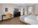 Inviting bedroom featuring a queen bed, dark dresser, and a desk with a chair at 4804 Cayview Ave # 20512, Orlando, FL 32819