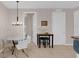 Cozy dining area featuring a glass table, white chairs, and modern lighting fixture at 4804 Cayview Ave # 20512, Orlando, FL 32819