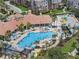 A resort-style swimming pool with palm trees, lounge chairs, and a large clubhouse in a multi-Gathering community at 4804 Cayview Ave # 20512, Orlando, FL 32819