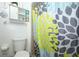 Bathroom with colorful floral shower curtain and decorative shelving at 5027 Vineland Rd # 5027, Orlando, FL 32811
