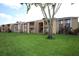 Two-story condo building featuring balconies and complemented by a mature tree, offering a scenic and inviting appeal at 5027 Vineland Rd # 5027, Orlando, FL 32811