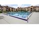 Large rectangular outdoor pool surrounded by a deck with lounge chairs, with views of the surrounding condo buildings at 5027 Vineland Rd # 5027, Orlando, FL 32811