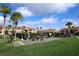Community grilling and picnic area with lush green grass and picnic tables, surrounded by condo buildings and palm trees at 5027 Vineland Rd # 5027, Orlando, FL 32811