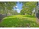 Lush green backyard features a large, open grassy area, mature shade trees, and a playground on the property at 513 Legacy Park Dr, Casselberry, FL 32707