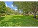 Large grassy backyard with mature shade trees and a playground for children to enjoy outside a residential home at 513 Legacy Park Dr, Casselberry, FL 32707