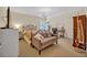 Cozy bedroom with an iron bed frame, sitting couch, chandelier, and desk with a mirror and natural light at 513 Legacy Park Dr, Casselberry, FL 32707