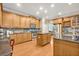 A spacious kitchen with wooden cabinets, stainless steel appliances, and a center island with dark countertops at 513 Legacy Park Dr, Casselberry, FL 32707