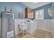 Well-lit laundry room with cabinetry, a utility sink, washer, dryer, and a 'Bless This Home' sign at 513 Legacy Park Dr, Casselberry, FL 32707