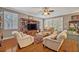 A cozy living room with hardwood floors, built-in shelving, plantation shutters, and comfortable seating at 513 Legacy Park Dr, Casselberry, FL 32707