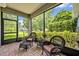A screened porch featuring brick flooring, wicker furniture, and views of lush greenery and neighborhood at 513 Legacy Park Dr, Casselberry, FL 32707