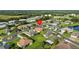 Scenic aerial shot of a residential area with well-maintained homes, green lawns, and a nearby lake at 5339 Pond Crossing Pl, Leesburg, FL 34748