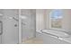Modern bathroom featuring tile shower and soaking tub next to an arched window at 5339 Pond Crossing Pl, Leesburg, FL 34748