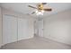 This bedroom features neutral carpet, a ceiling fan, and a closet for ample storage at 5339 Pond Crossing Pl, Leesburg, FL 34748