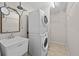 This is a laundry room with a sink, stacked washer and dryer, shelves, and tiled floor at 5339 Pond Crossing Pl, Leesburg, FL 34748