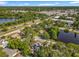 Picturesque overhead perspective of a residential zone, showcasing a pond and commercial buildings, lush vegetation under a blue sky at 604 Thrush Ave, Longwood, FL 32750