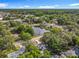 Overhead capture of a neighborhood with homes, a pond reflecting the sky, and surrounded by rich, green vegetation and tree canopies at 604 Thrush Ave, Longwood, FL 32750