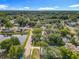 Aerial view of a residential area showcasing tree-lined streets, and a serene pond surrounded by lush greenery and cozy homes at 604 Thrush Ave, Longwood, FL 32750