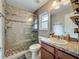 Bathroom featuring tiled stand up shower with sliding glass doors, neutral colored walls and flooring and granite vanity at 604 Thrush Ave, Longwood, FL 32750