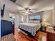 Comfortable bedroom features hardwood floors, ceiling fan, and a walk-in closet for ample storage space at 604 Thrush Ave, Longwood, FL 32750
