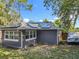 Rear exterior view of a home with a gray block wall and roof mounted solar panels at 604 Thrush Ave, Longwood, FL 32750
