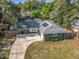 Aerial view of a home with a long driveway, well-maintained landscaping, and partial solar panels at 604 Thrush Ave, Longwood, FL 32750
