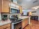 Modern kitchen featuring stainless steel appliances, light wood cabinets, and a view into living room at 604 Thrush Ave, Longwood, FL 32750