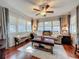 Bright living room featuring hardwood floors, plush seating, and plenty of natural light from large windows at 604 Thrush Ave, Longwood, FL 32750