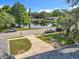 Scenic view of a tranquil pond in a residential neighborhood with lush trees and parked cars under a bright blue sky at 604 Thrush Ave, Longwood, FL 32750