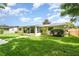 Backyard view with a screened in porch, green grass, and perimeter fence at 692 Gaslight Dr, South Daytona, FL 32119