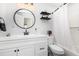 Bathroom with a modern white vanity, round mirror, and tub/shower with white tile and black accents at 692 Gaslight Dr, South Daytona, FL 32119