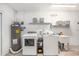 Clean and functional laundry room with washer, dryer, utility sink, water heater and ample storage space at 692 Gaslight Dr, South Daytona, FL 32119