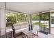 Relaxing sunroom featuring a comfortable sofa, a coffee table, and lots of natural light from the surrounding windows at 692 Gaslight Dr, South Daytona, FL 32119