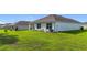 Lush green backyard featuring newly built single story home with well manicured lawn at 7161 Sw 135Th Pl, Ocala, FL 34473