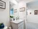 Cozy powder room with white vanity and decorative framed artwork at 7161 Sw 135Th Pl, Ocala, FL 34473