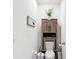 Bathroom with assistive handrails, white fixtures and wooden cabinet at 7161 Sw 135Th Pl, Ocala, FL 34473