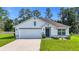 Well maintained single Gathering home with a two car garage, manicured front lawn and tidy landscaping at 7161 Sw 135Th Pl, Ocala, FL 34473