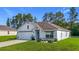Well maintained single Gathering home with a two car garage, manicured front lawn and flower beds at 7161 Sw 135Th Pl, Ocala, FL 34473