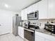 Well-lit kitchen featuring stainless steel appliances and white cabinetry at 7161 Sw 135Th Pl, Ocala, FL 34473