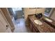 Bathroom with a granite vanity, white sink, and tub, offering both style and functionality at 844 Suffolk Pl, Davenport, FL 33896