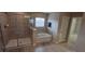 Bathroom featuring a glass-enclosed shower, jetted tub, and a doorway leading to the closet at 844 Suffolk Pl, Davenport, FL 33896