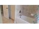 Bathroom showing tub with tiled walls and decorative shower curtain at 844 Suffolk Pl, Davenport, FL 33896