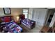 Comfortable bedroom features twin beds with patriotic quilts and a double-door closet for storage at 844 Suffolk Pl, Davenport, FL 33896