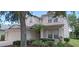 Inviting two-story home featuring a landscaped front yard with a palm tree and lush green bushes at 844 Suffolk Pl, Davenport, FL 33896