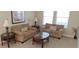 Cozy living room featuring comfortable sofas, wooden tables, and natural light from the window at 844 Suffolk Pl, Davenport, FL 33896