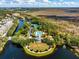 Aerial view of a community pool, tennis courts, and waterway surrounded by green trees and residential buildings at 922 Jasmine St, Celebration, FL 34747
